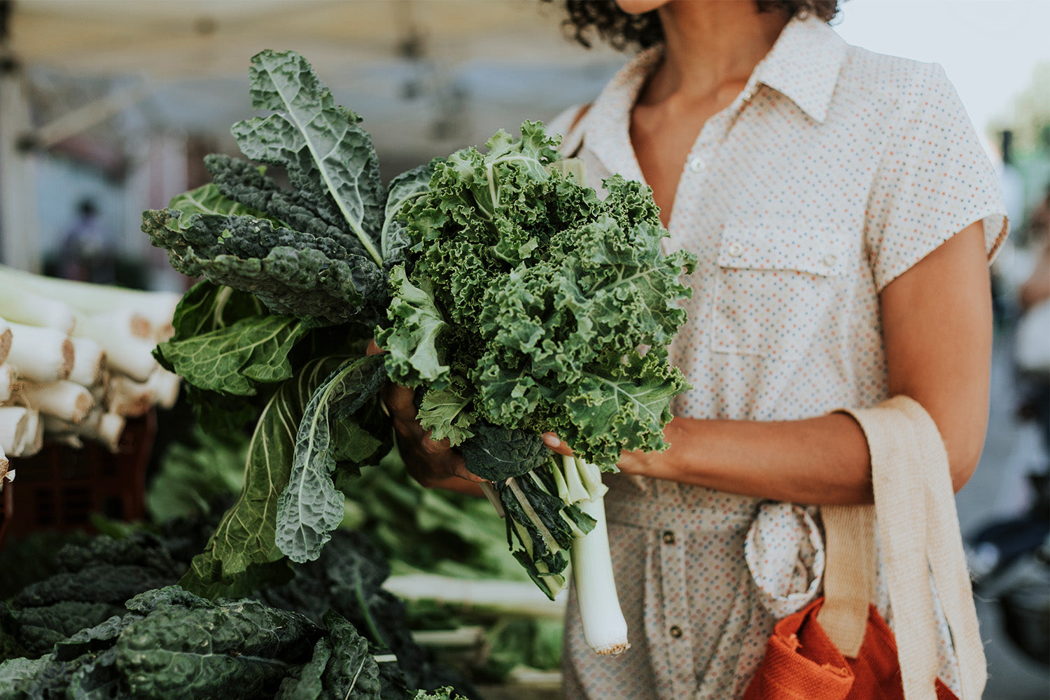 A woman holding different types of greens