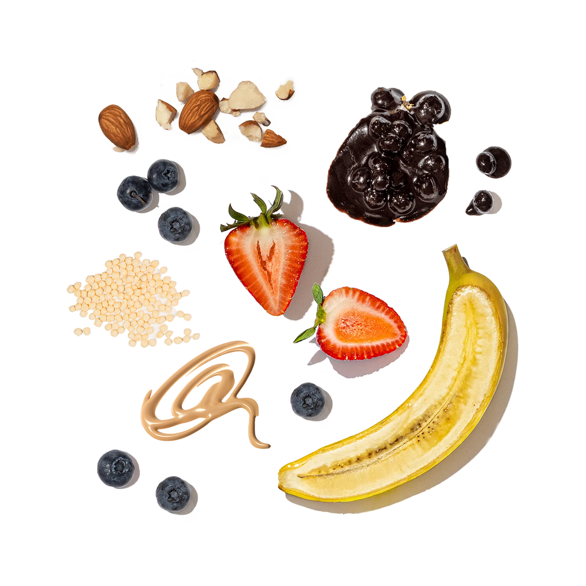 Fruits, nuts, and a banana arranged on a white background