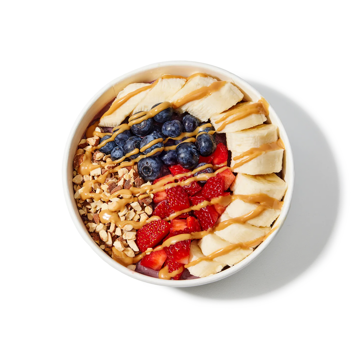 Fruit bowl with bananas, blueberries, strawberries, and nuts on a white background