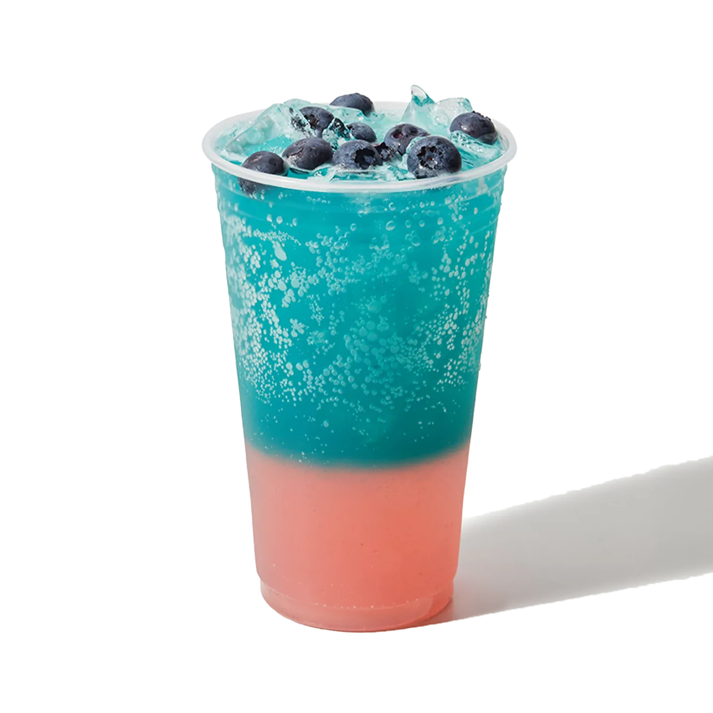 Blue and pink layered drink with blueberries on a white background