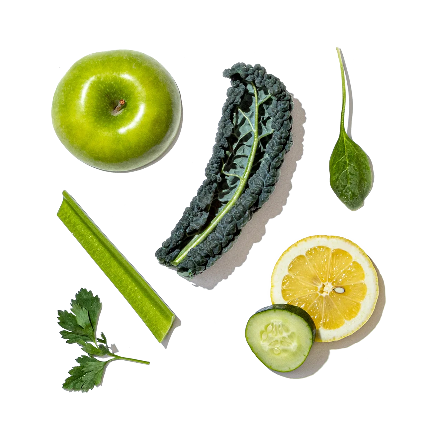 Collection of green fruits, vegetables, and a lemon on a white background