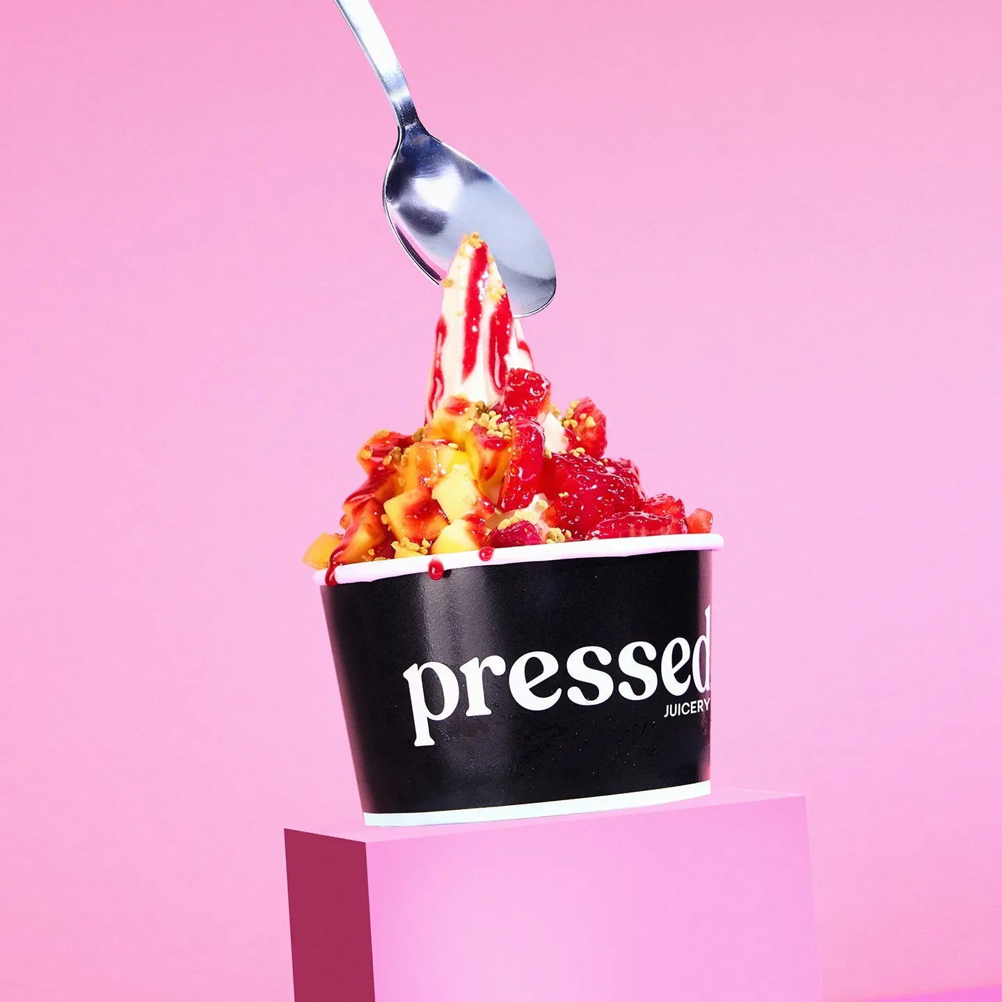 Pressed Juicery Glow Up Sundae in a Pressed cup on a pink background.