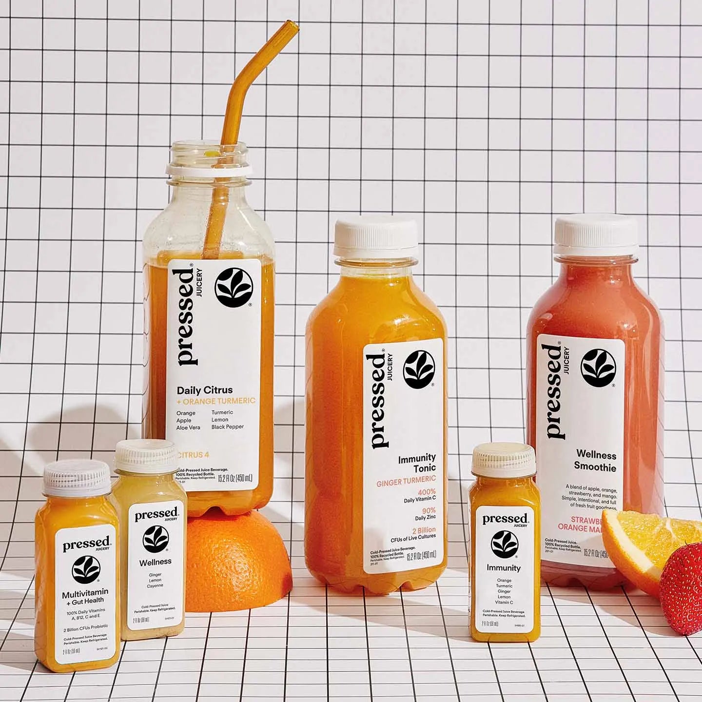 Collection of 'pressed' juice bottles and containers on a grid background