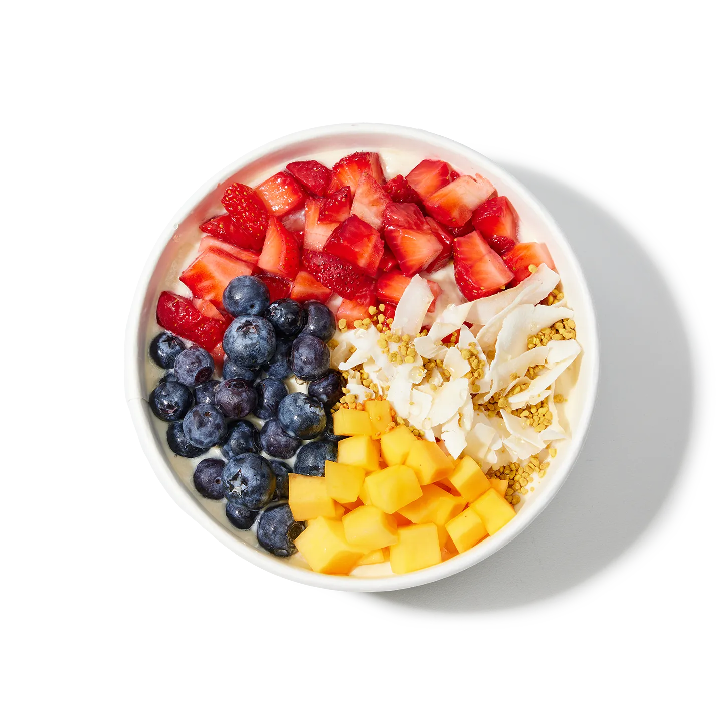 Fruit salad bowl with strawberries, blueberries, mango, and coconut on a white background