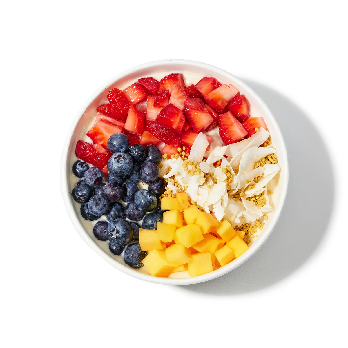 Pressed Juicery Beauty Bowl with strawberries, blueberries, mango, and coconut on a white background.
