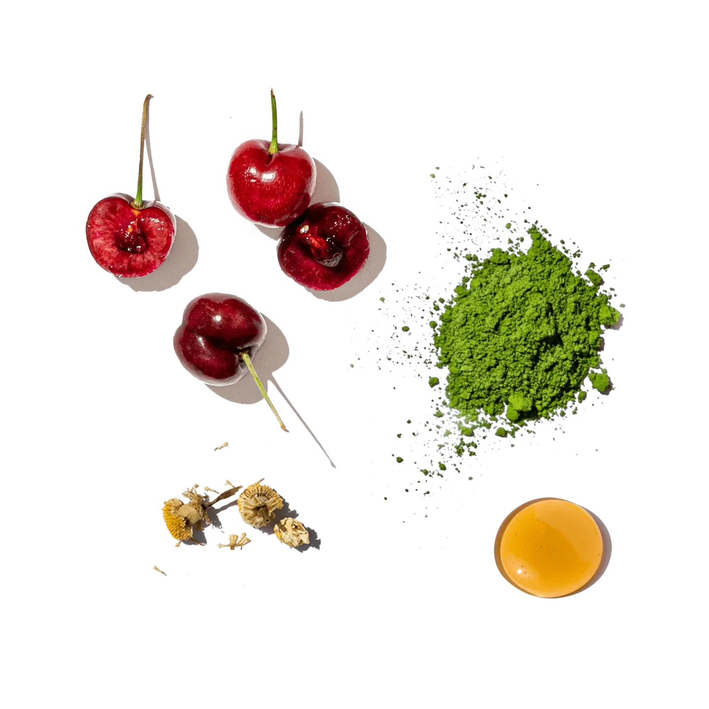 Cherries, matcha powder, honey, and dried flowers on a white background