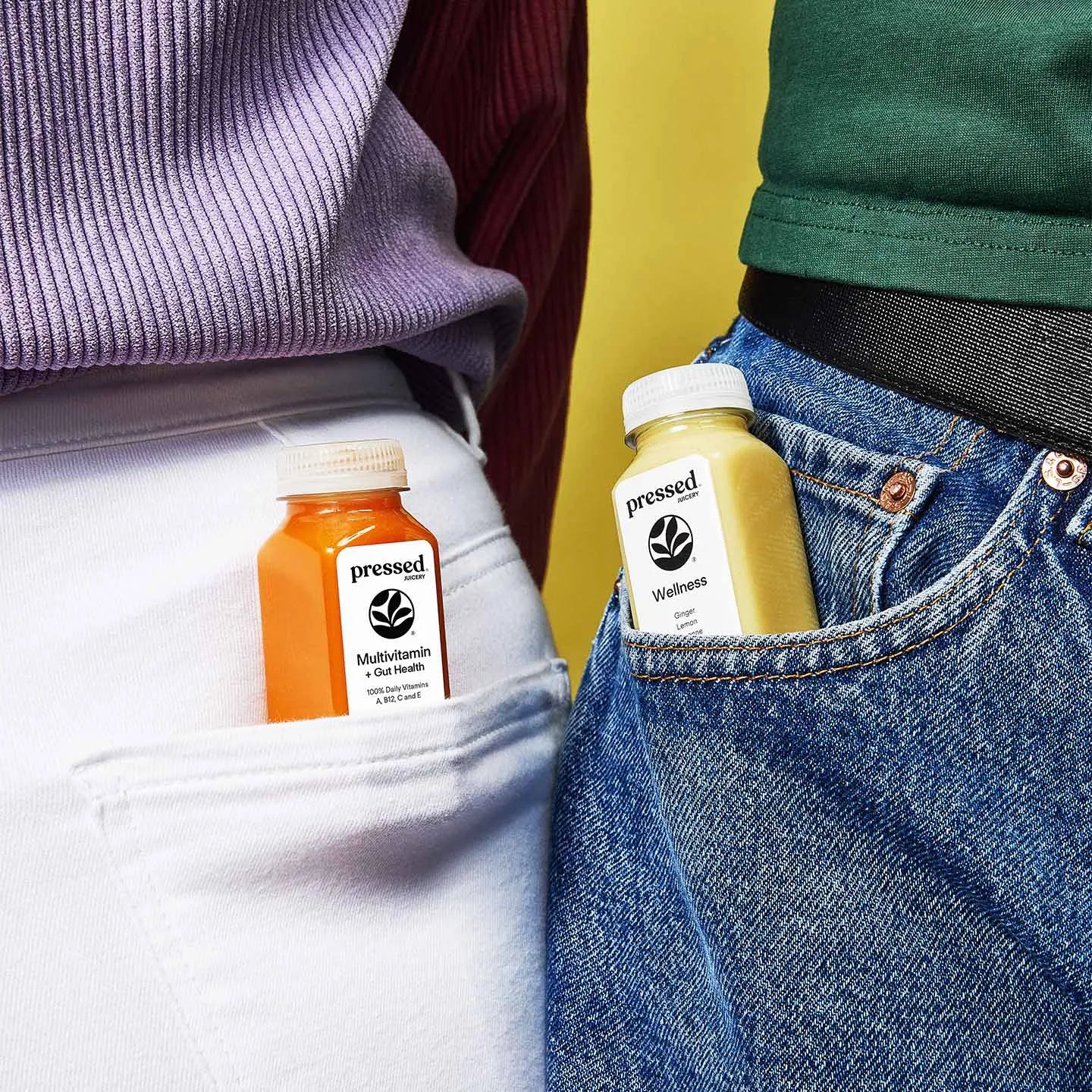 Two people carrying Pressed Juicery wellness shots (Multivitamin + Gut Health Shot and Wellness Shot) in their jeans pockets.