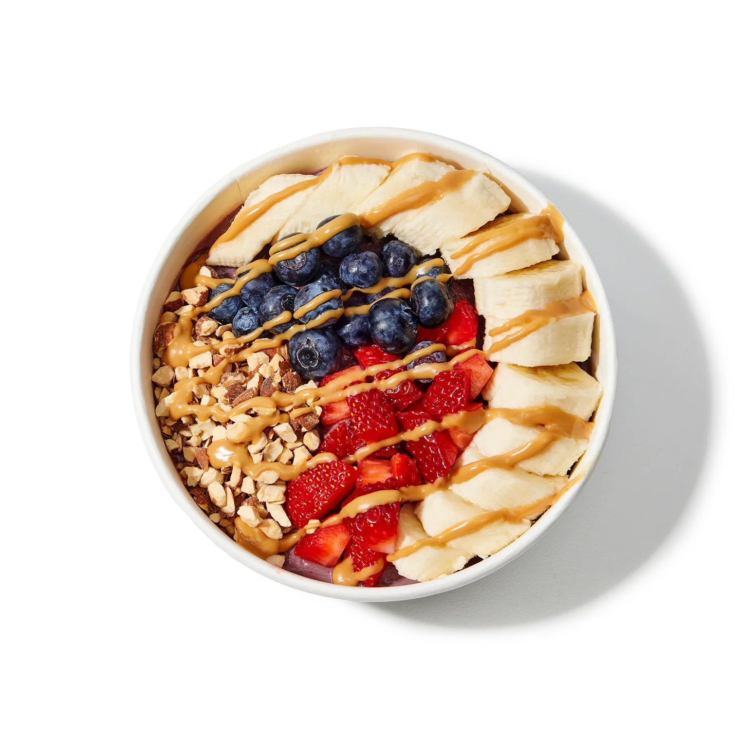 Fruit bowl with bananas, blueberries, strawberries, and nuts on a white background