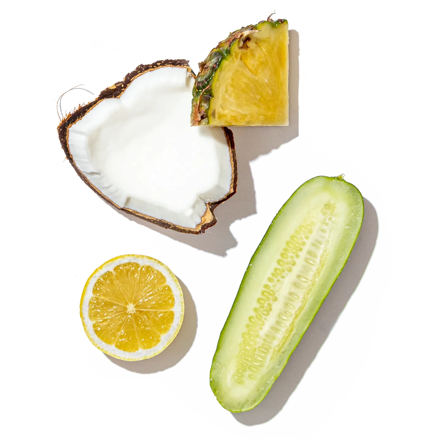 Collage of sliced pineapple, coconut, lemon, and cucumber on a white background