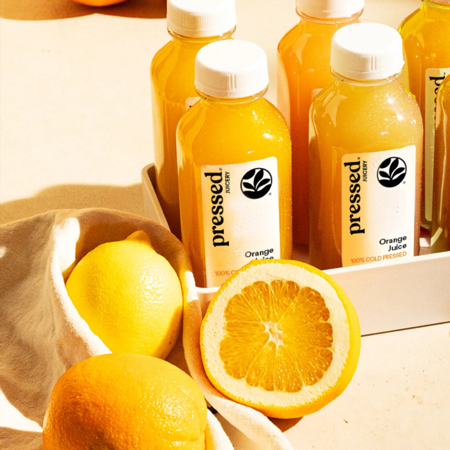 Bottles of pressed orange juice with lemons on a wooden surface