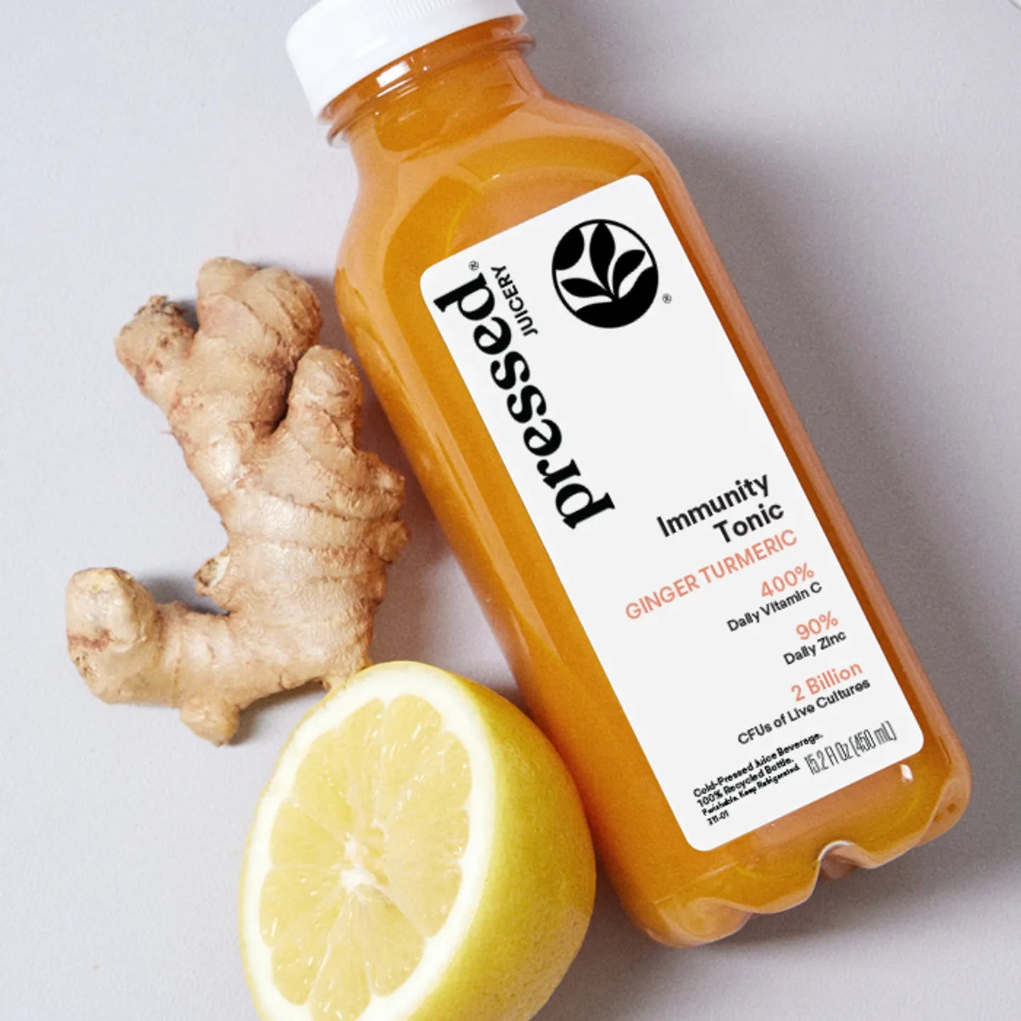Bottle of pressa immunity tonic with ginger root and lemon on a light background