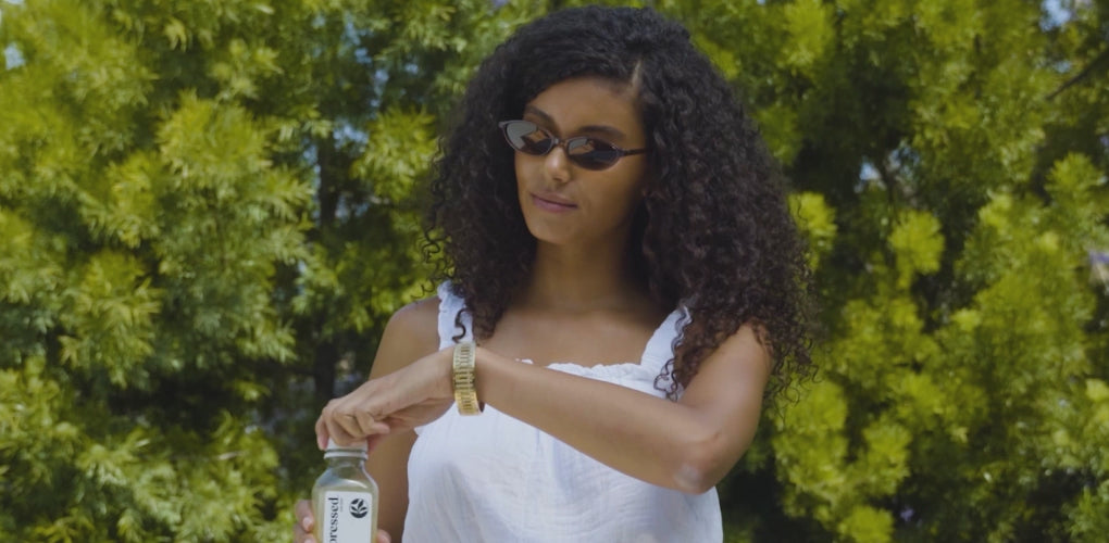 Woman enjoying Pressed Juicery Vacation Prep Pack by the pool with Simple Cleanse juice and Debloat Shot for debloat support.